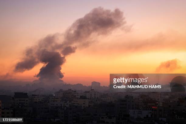 Fire and smoke rise above buildings in Gaza City during an Israeli air strike, on October 13 as raging battles between Israel and the Hamas movement...