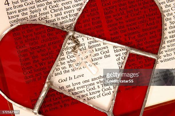 religiöse: bibel schriften eingemeißelt gott ist liebe mit buntglas herz - love is /// stock-fotos und bilder