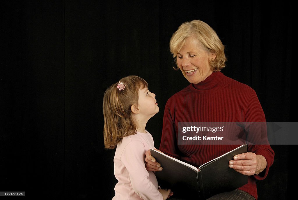 Grandmother with granddaughter reading