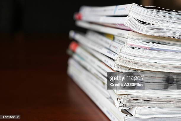 stack of magazines over a wooden desk - magazine stack stock pictures, royalty-free photos & images