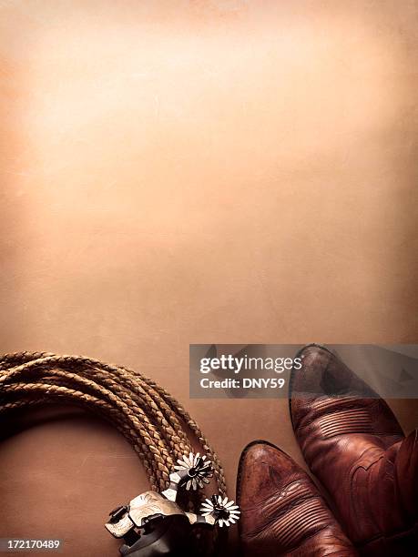 spurs next to cowboy boots and lasso on leather surface - boot spur stock pictures, royalty-free photos & images