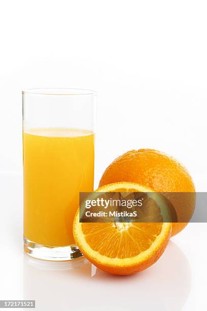 a glass of orange juice by two oranges on a white background - orange juice glass white background stock pictures, royalty-free photos & images