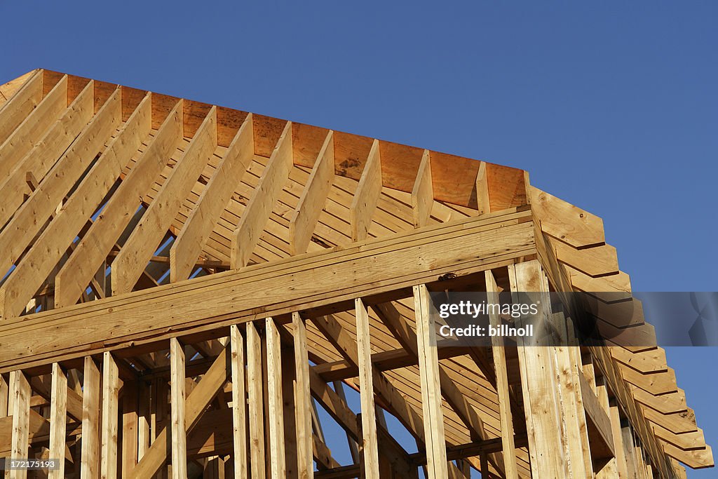 Wooden house frame against blue sky