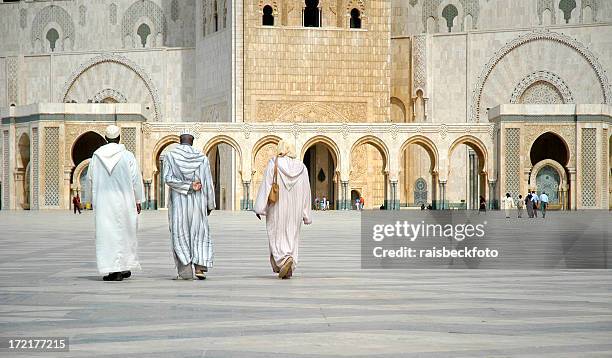 worshippers walk towards hassan ii mosque, casablanca, morocco - casablanca morocco stock pictures, royalty-free photos & images