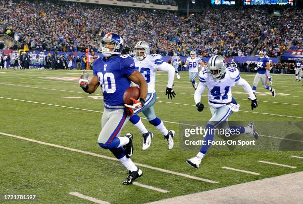 Victor Cruz of the New York Giants races down the sidelines to score a touchdown out running Gerald Sensabaugh and Terence Newman of the Dallas...