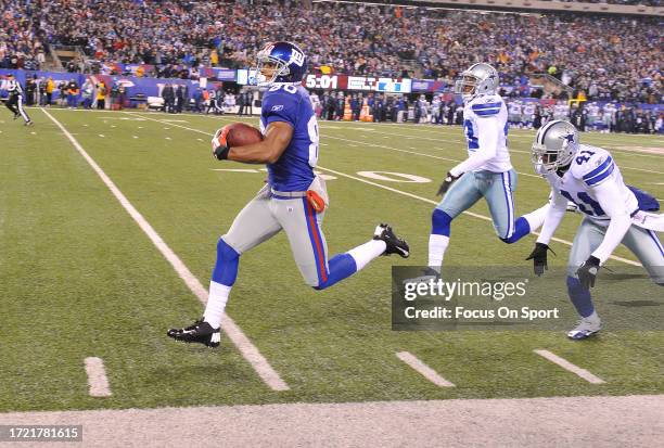 Victor Cruz of the New York Giants races down the sidelines to score a touchdown out running Gerald Sensabaugh and Terence Newman of the Dallas...