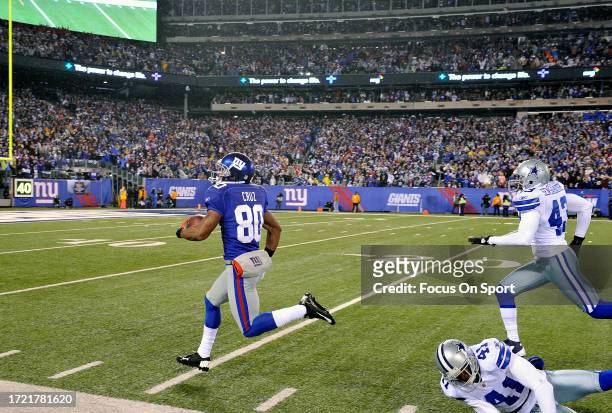 Victor Cruz of the New York Giants races down the sidelines to score a touchdown out running Gerald Sensabaugh and Terence Newman of the Dallas...