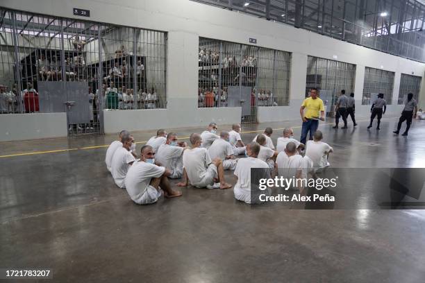 Gang members of the "Mara Salvatrucha" and "Barrio 18" receive religious talk in the interior at CECOT on October 12, 2023 in Tecoluca, El Salvador....