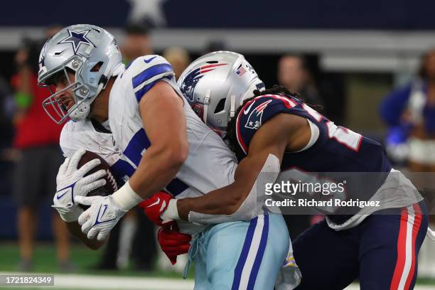 Jake Ferguson of the Dallas Cowboys is tackled by Kyle Dugger of the New England Patriots at AT&T Stadium on October 01, 2023 in Arlington, Texas.
