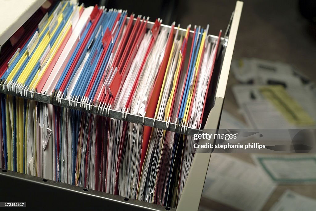 Open File Cabinet with Papers Spread Out on the Floor