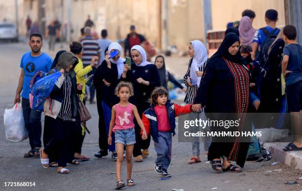 Palestinians carrying their belongings flee to safer areas in Gaza City after Israeli air strikes, on October 13, 2023. Israel has called for the...