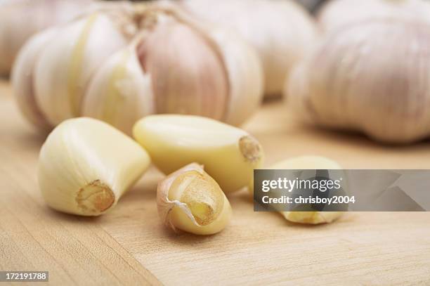 garlic cloves on a wooden board - onion family stock pictures, royalty-free photos & images
