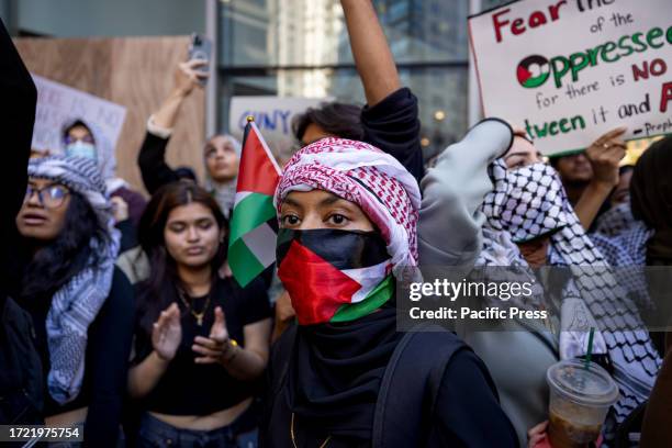 Students from Hunter College chant and hold up signs during a pro-Palestinian demonstration at the entrance of their campus. The pro-Palestinian...