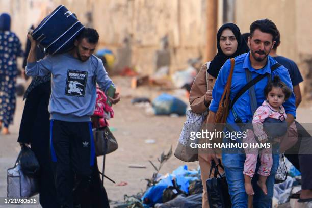 Palestinians with their belongings flee from their homes following Israeli airstrikes in Gaza City on October 13, 2023. Israel has called for the...