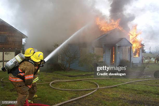 firefighters fighting house fire - extinguishing stock pictures, royalty-free photos & images