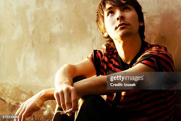 smoking young man - boys smoking cigarettes stock pictures, royalty-free photos & images