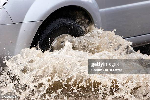 splash by a car as it goes through flood water - car splashing stock pictures, royalty-free photos & images