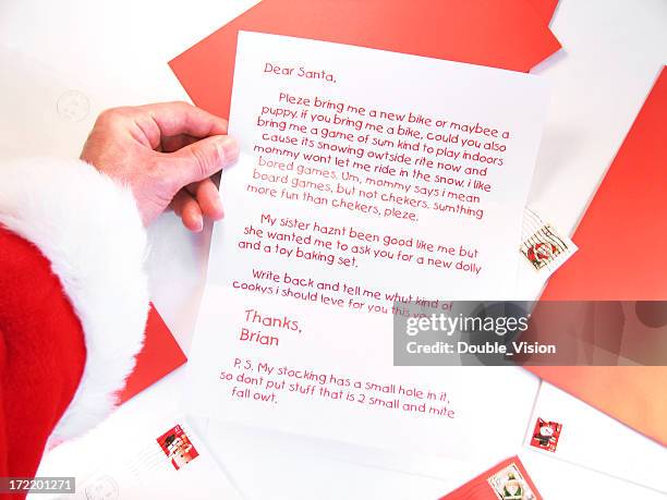 santa holds and reads a christmas letter from a child - child writing letter to santa stock pictures, royalty-free photos & images