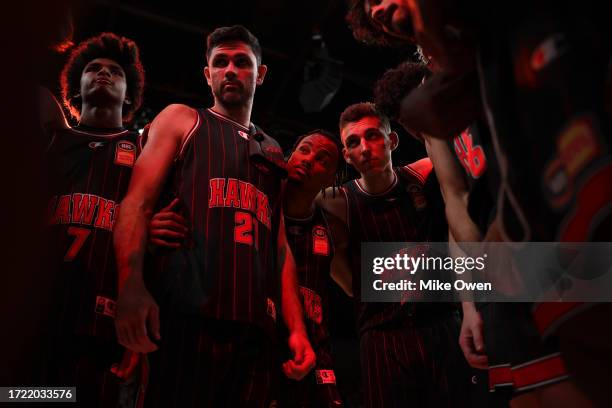 Todd Blanchfield , Justin Robinson and Mason Peatling of the Hawks looks on while in a huddle after the team's victory in the round two NBL match...