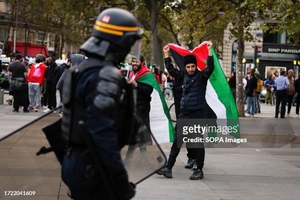 Man with a Palestine flag seen passing by a police officer during the pro-Palestinian protest. Despite French Minister of the Interior, Gérald...