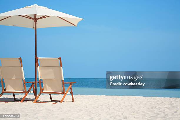 leere stühle und sonnenschirm am strand in florida, usa - wetterfester stuhl stock-fotos und bilder