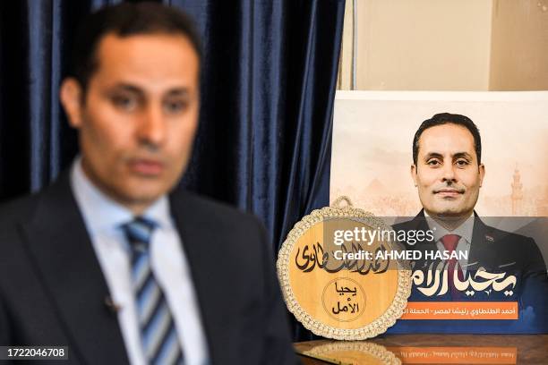 Egyptian presidential hopeful Ahmed al-Tantawi looks on next to a campaign poster and a plaque bearing his slogan "long live hope", during an...