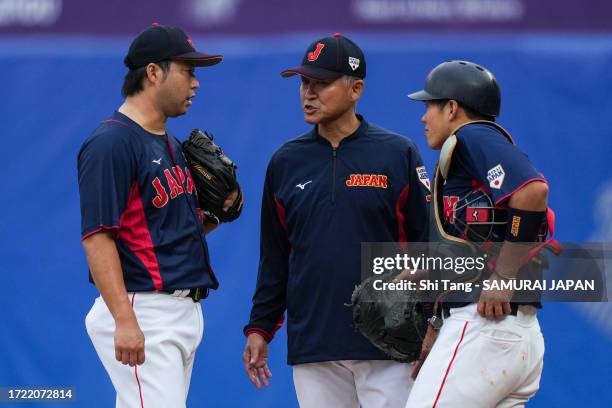 Junichi Tazawa of Team Japan talks with his teammate in the 6th inning during the baseball bronze medal game between Japan and China on day fourteen...