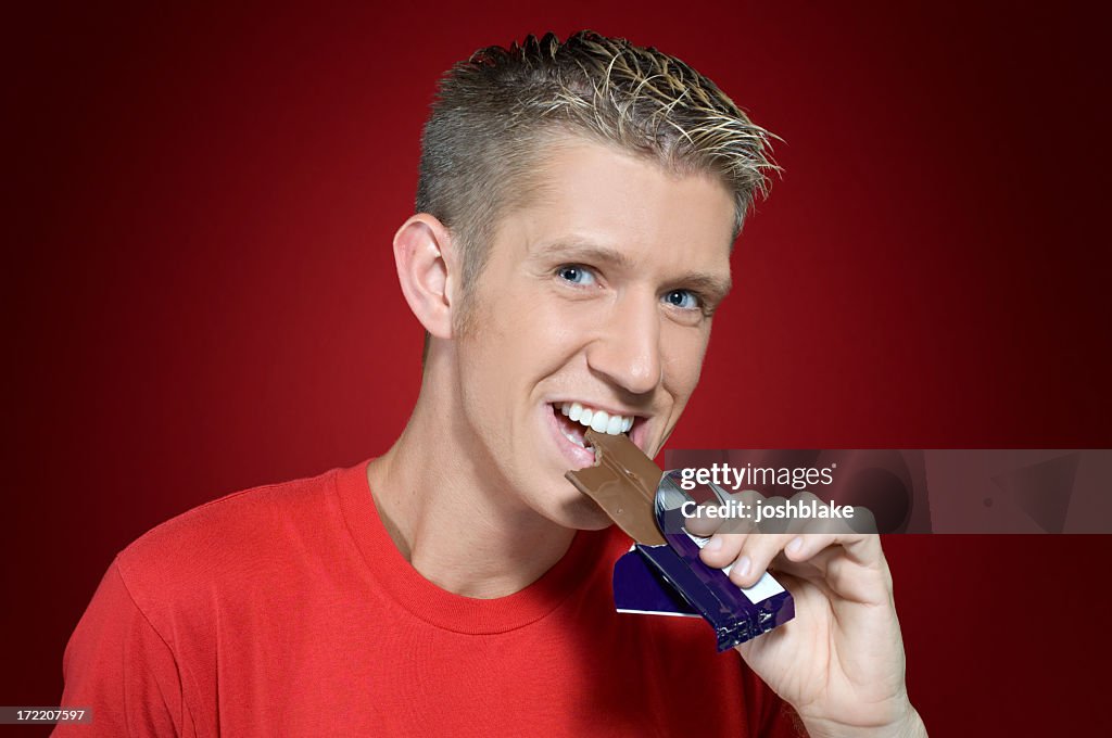 A man taking a bite of chocolate