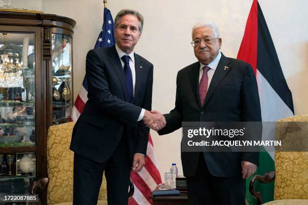 Secretary of State Antony Blinken shakes hands with Palestinian president Mahmud Abbas during their meeting in Jordan's capital Amman on October 13,...