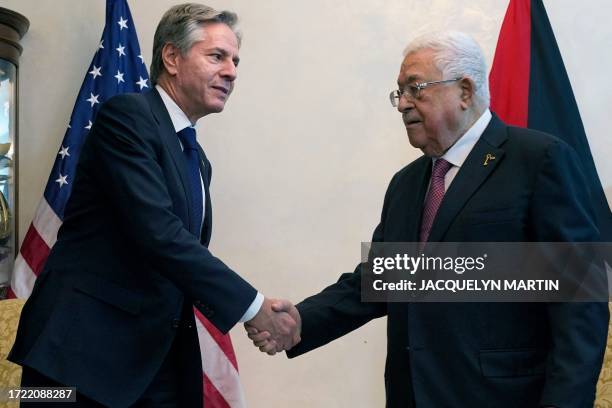 Secretary of State Antony Blinken shakes hands with Palestinian president Mahmud Abbas during their meeting in Jordan's capital Amman on October 13,...