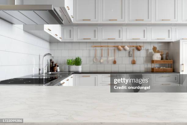 empty white marble countertop with blurred kitchen background - kookeiland stockfoto's en -beelden