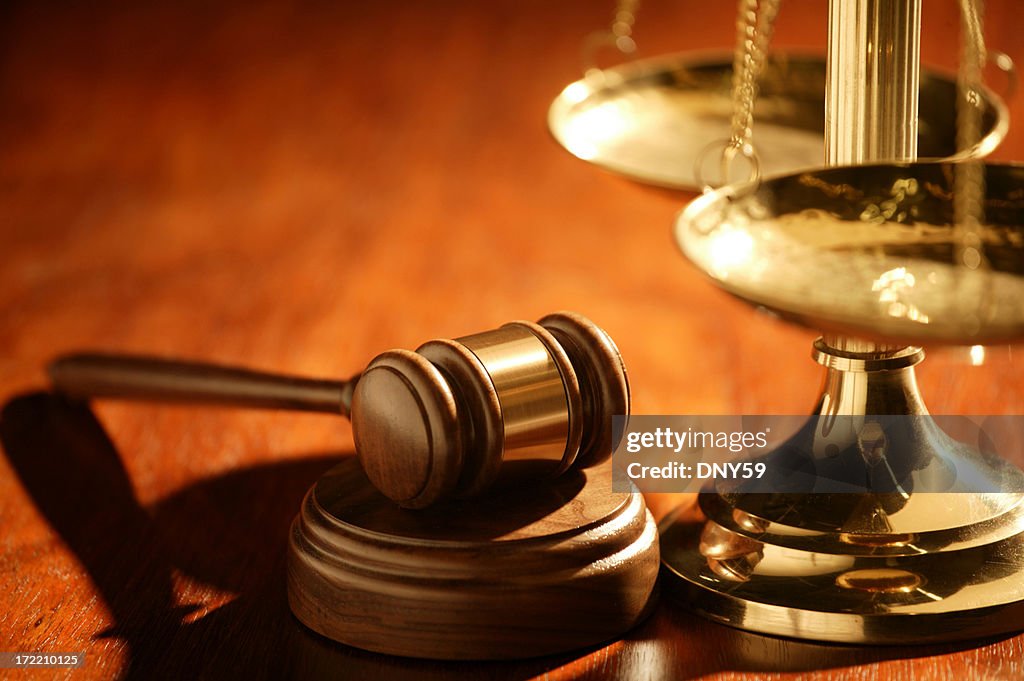 Gavel and scale of justice on wood table