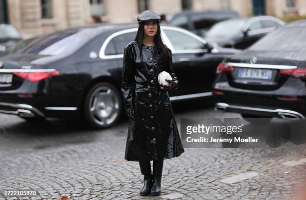Yoyo Cao is seen outside Chanel show wearing black leather barrett, black patent Chanel coat, black leather high knee boots, white camellia Chanel...