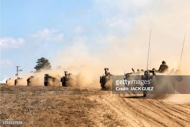 Israeli army tanks and vehicles deploy along the border with the Gaza Strip in southern Israel on October 13, 2023. Thousands of people, both Israeli...