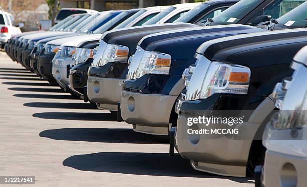 side view of a long row of automobile front bumpers in a lot - suv stockfoto's en -beelden