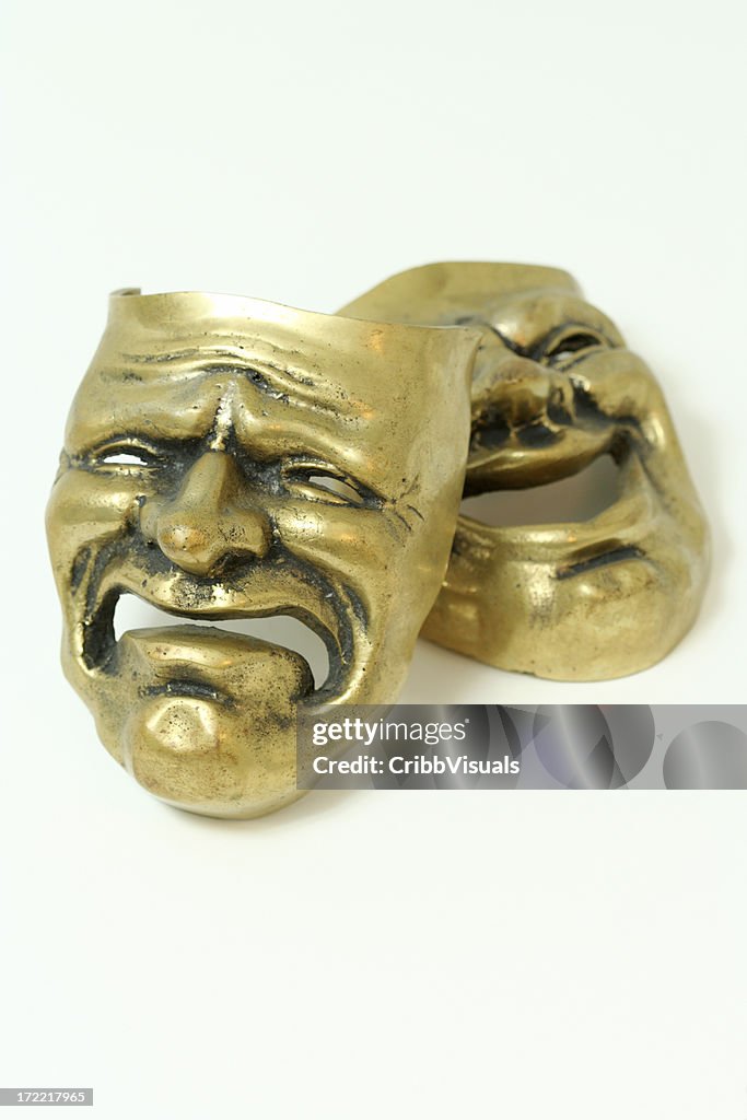 Comedy and tragedy brass masks on white background