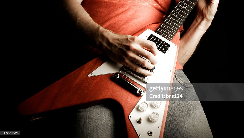 A person playing a rock and roll guitar