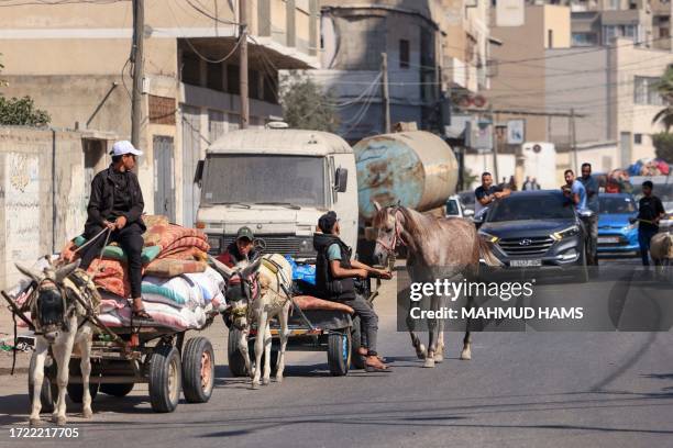 Palestinians with their belongings flee to safer areas in Gaza City after Israeli air strikes, on October 13, 2023. Israel has called for the...