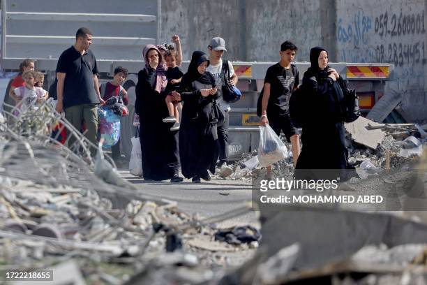 Palestinians with their belongings flee to safer areas in Gaza City after Israeli air strikes, on October 13, 2023. Israel has called for the...