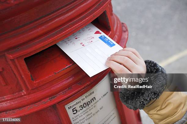 tiny hand pushing a postcard inside a postbox - postcards stock pictures, royalty-free photos & images