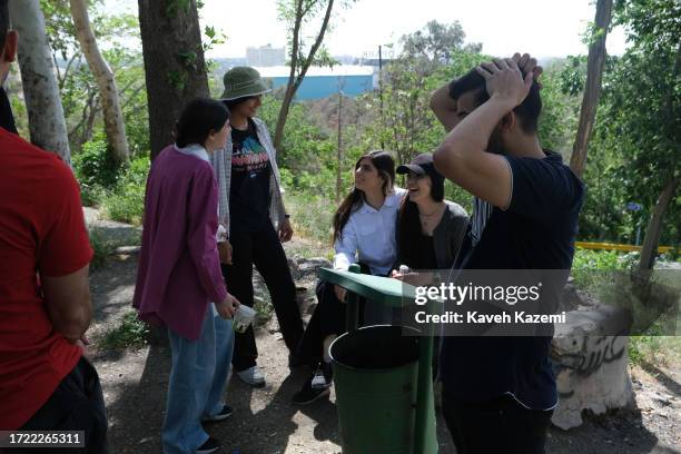 Group of mixed young adults with women not wearing their hijab spend the day chilling out in Chitgar Park on April 23, 2023 in Tehran, Iran. As a...