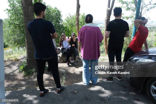 Group of mixed young adults with women not wearing their hijab spend the day chilling out in Chitgar Park on April 23, 2023 in Tehran, Iran. As a...