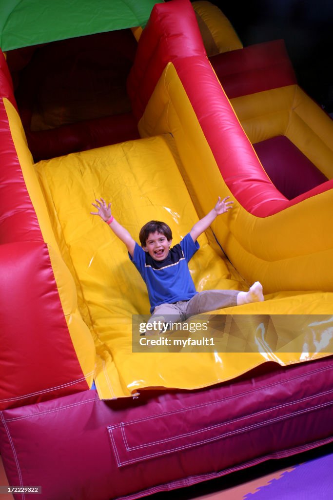 Boy on inflatable slide goes fast