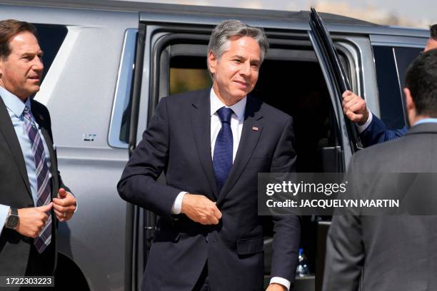 Secretary of State Antony Blinken disembarks from his vehicle to board his plane while departing from the airport in Amman on October 13, 2023 on his...