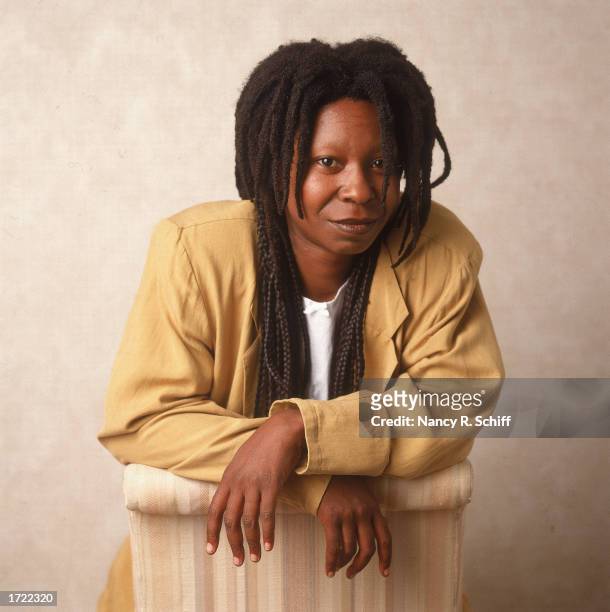 Studio portrait of American actor and comedian Whoopi Goldberg leaning on a chair, 1988.