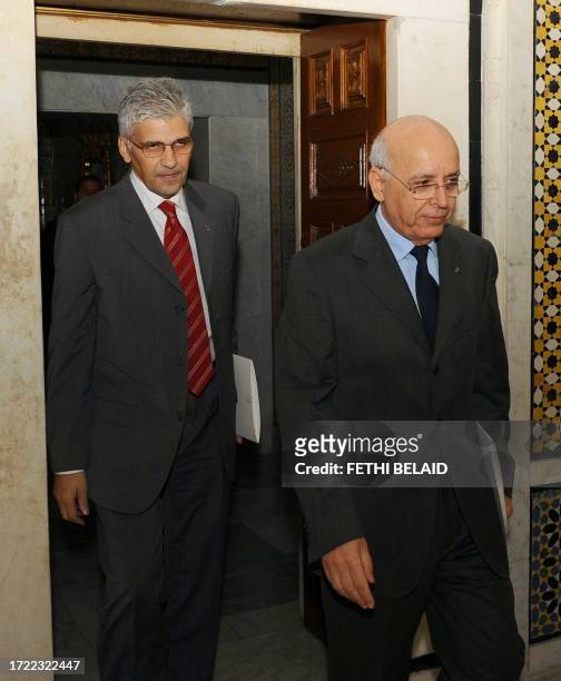 Tunisian Prime Minister Mohamed Ghannouchi walks withTunisian development and International Cooperation Minister Mohamed Nouri Jouini before his...