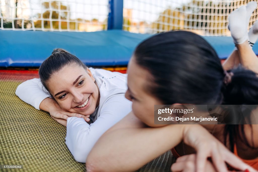 Deux jeunes femmes en forme et belles allongées sur un trampoline ensemble