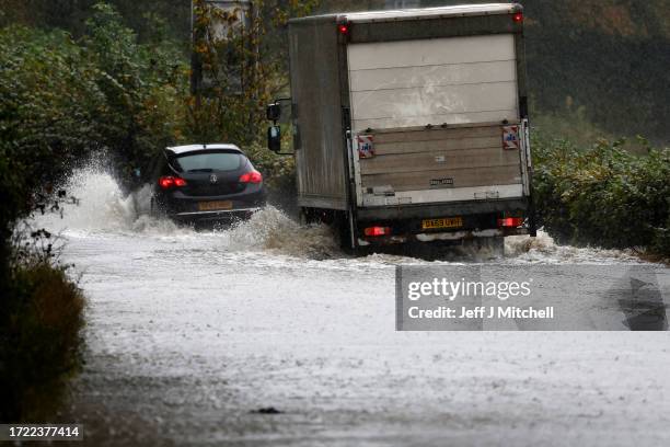 Members of the public struggle with flooding as torrential rain continues on October 07, 2023 in Dumbarton, United Kingdom. The UK is experiencing...