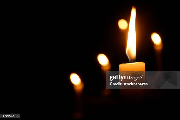 candles burning in dark church - candle stock pictures, royalty-free photos & images