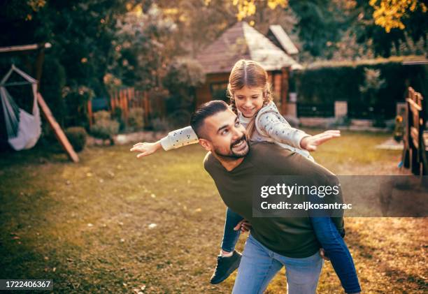 dad and his children are playing in the yard - modern manhood stock pictures, royalty-free photos & images